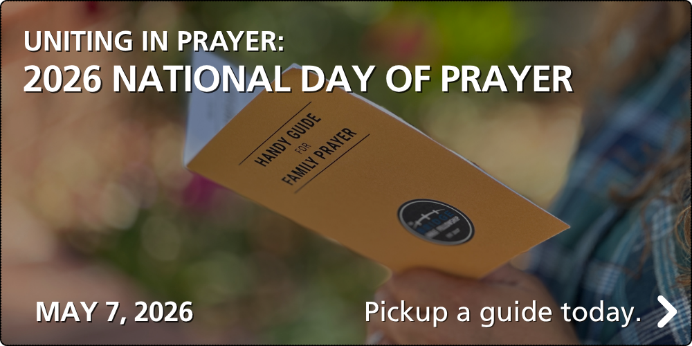 Image of a woman holding a Handy Guide for Family Prayer booklet.